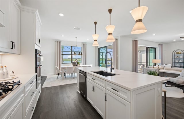 kitchen featuring dark wood-style floors, light countertops, open floor plan, a sink, and dishwashing machine