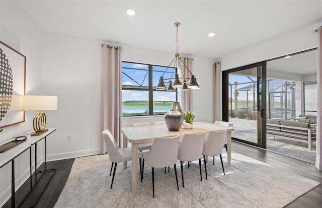 dining room with a notable chandelier, baseboards, wood finished floors, and recessed lighting