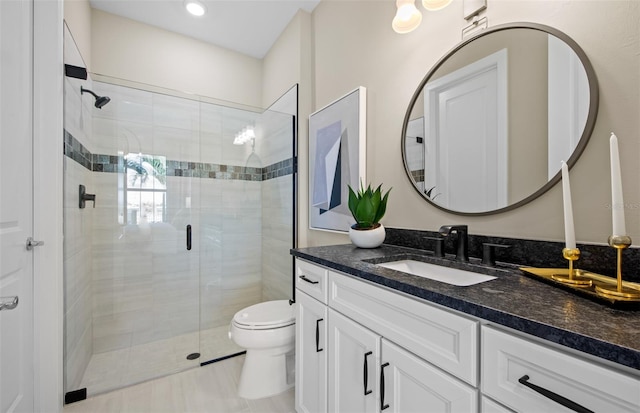 bathroom with a shower stall, toilet, and vanity