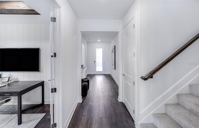 interior space featuring dark wood-type flooring, baseboards, and stairs