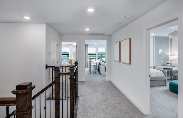 corridor featuring visible vents, baseboards, carpet, an upstairs landing, and recessed lighting