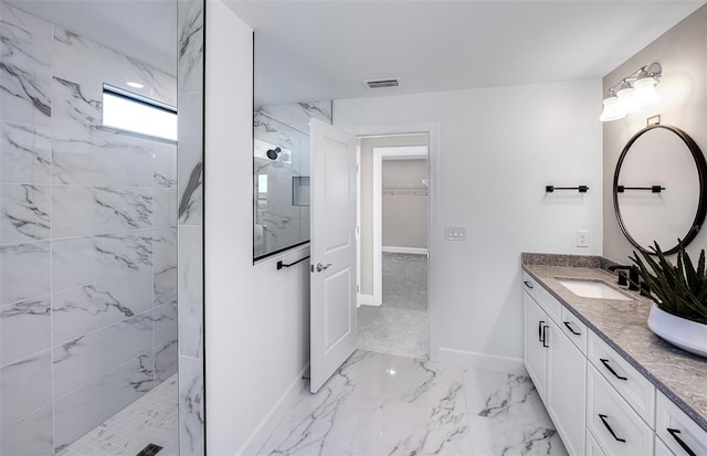 bathroom featuring marble finish floor, a marble finish shower, visible vents, vanity, and baseboards