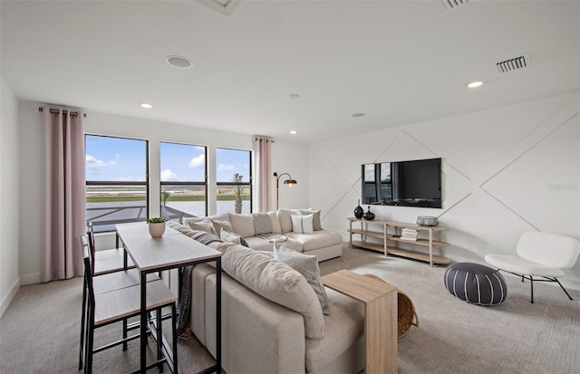 living area featuring light carpet, visible vents, and recessed lighting