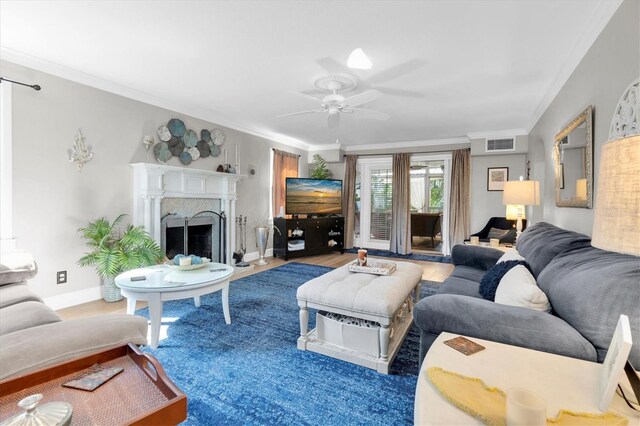 living area featuring ceiling fan, a high end fireplace, visible vents, baseboards, and ornamental molding