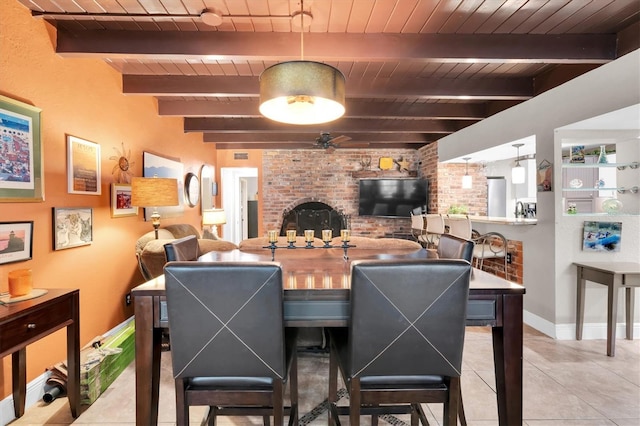 tiled dining space with brick wall, wood ceiling, baseboards, and beam ceiling