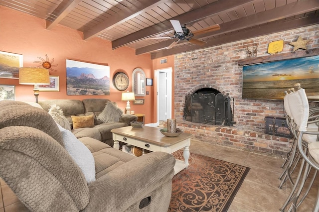 tiled living area featuring beam ceiling, a brick fireplace, and wooden ceiling