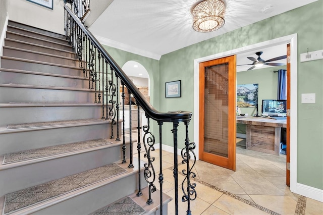 staircase with tile patterned flooring, arched walkways, and baseboards