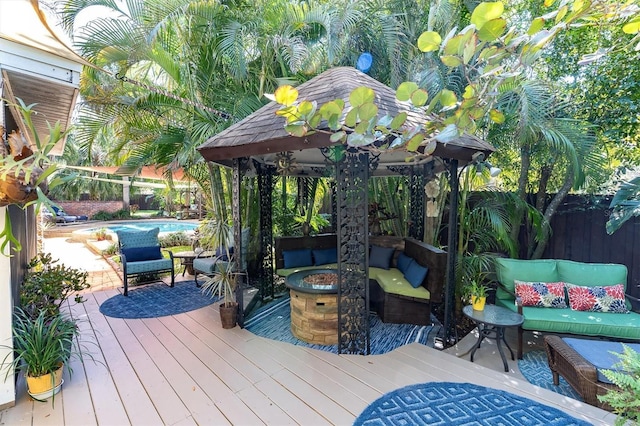 wooden deck with a gazebo, a fenced backyard, a fenced in pool, and an outdoor living space with a fire pit