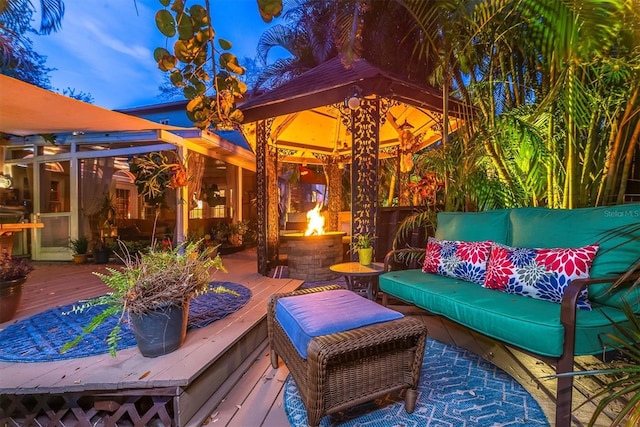 view of patio with an outdoor living space with a fire pit, a gazebo, and a wooden deck