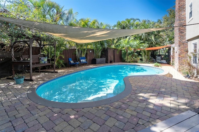 outdoor pool with a patio area and a fenced backyard