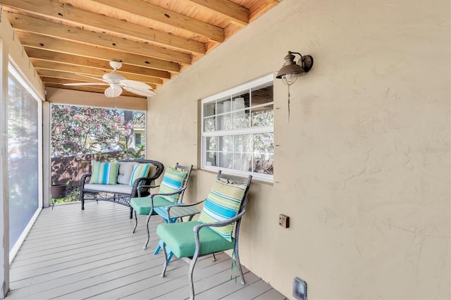 sunroom featuring wooden ceiling, a ceiling fan, and beam ceiling