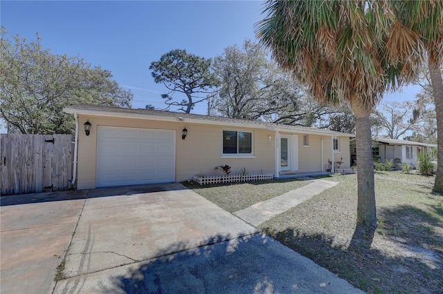 ranch-style home with a garage, fence, and concrete driveway