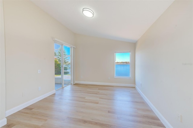 unfurnished room featuring a healthy amount of sunlight, light wood-style flooring, and baseboards