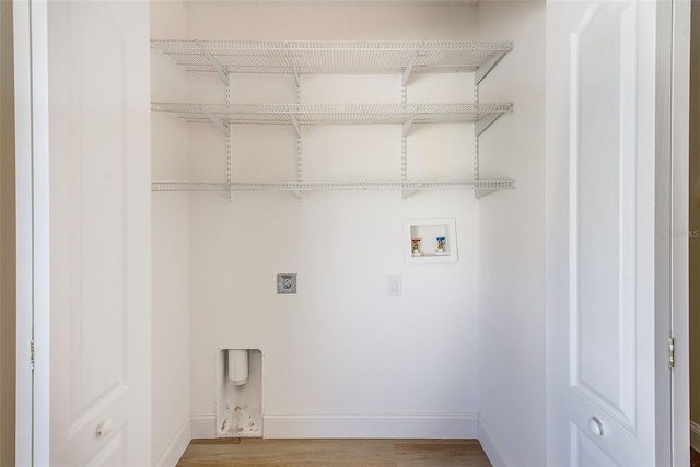 clothes washing area with baseboards, washer hookup, wood finished floors, and hookup for an electric dryer