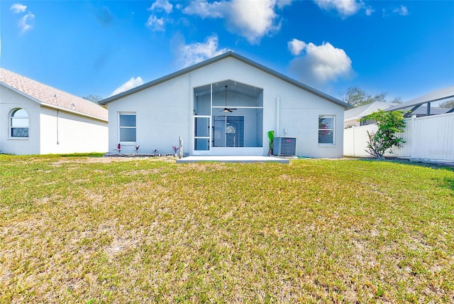 rear view of property featuring a yard, central air condition unit, stucco siding, ceiling fan, and fence