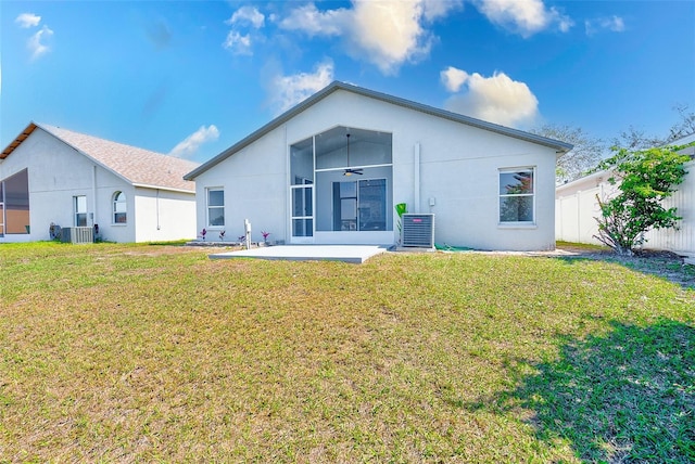 rear view of house with central air condition unit, fence, a yard, stucco siding, and a patio area