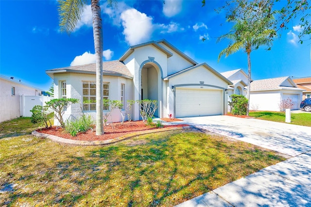 view of front facade with an attached garage, fence, driveway, stucco siding, and a front lawn