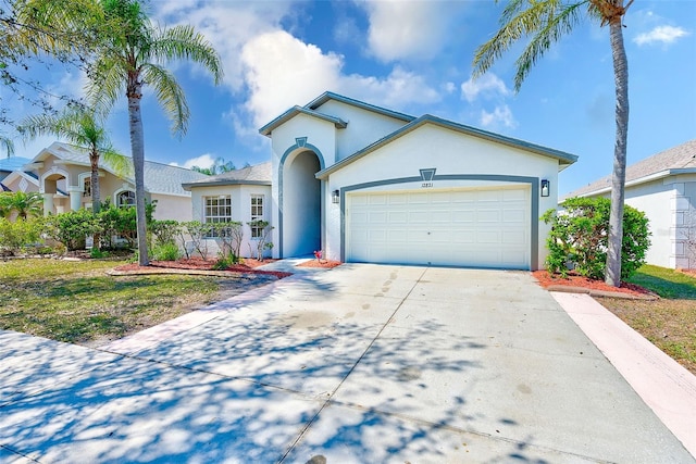 single story home with driveway, an attached garage, and stucco siding