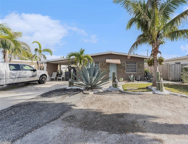 view of front of house with driveway, fence, and an attached carport