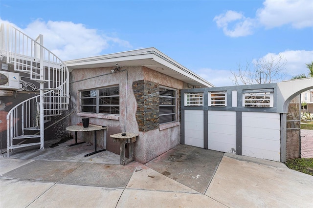 view of home's exterior featuring ac unit, stucco siding, a patio, and stairs