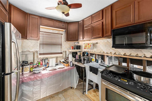 kitchen featuring light tile patterned floors, a ceiling fan, appliances with stainless steel finishes, backsplash, and brown cabinetry