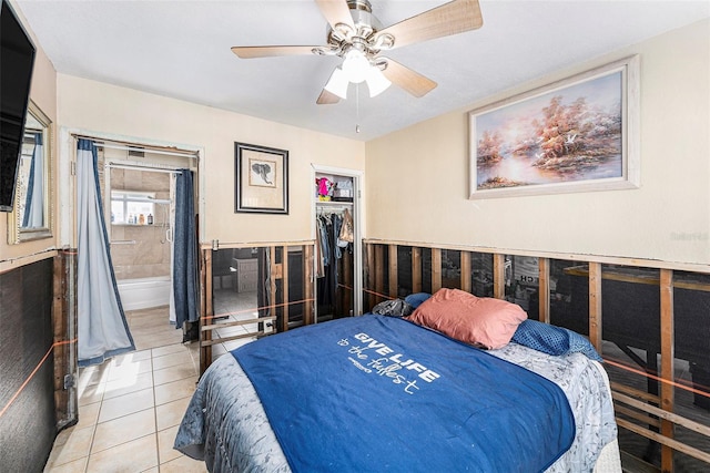 bedroom with light tile patterned floors, connected bathroom, a ceiling fan, a closet, and a walk in closet