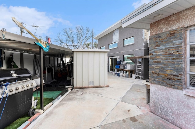 view of patio with a storage shed, area for grilling, and an outdoor structure