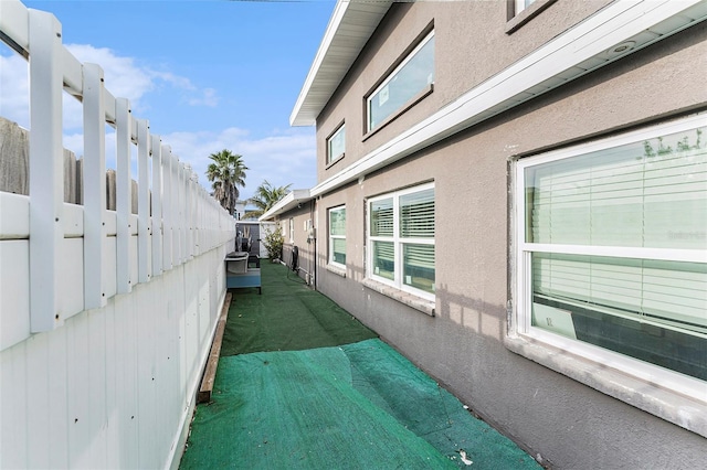 view of home's exterior with fence and stucco siding