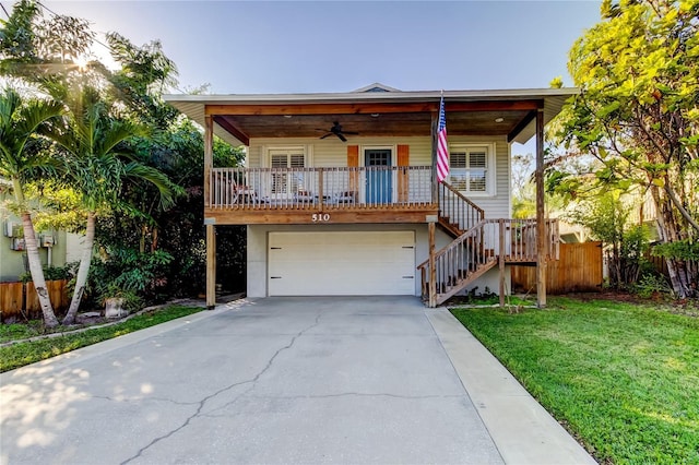 view of front of property with stairway, driveway, a front lawn, a porch, and ceiling fan