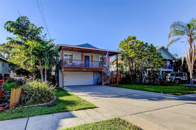 view of front of house featuring ceiling fan, a front lawn, stairs, an attached garage, and concrete driveway