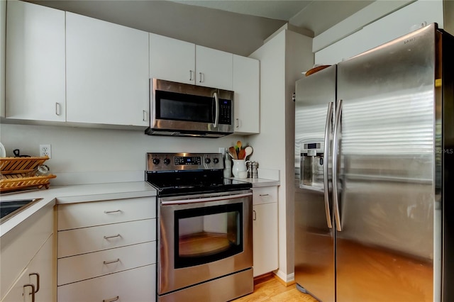 kitchen featuring stainless steel appliances, light wood-type flooring, light countertops, and white cabinetry