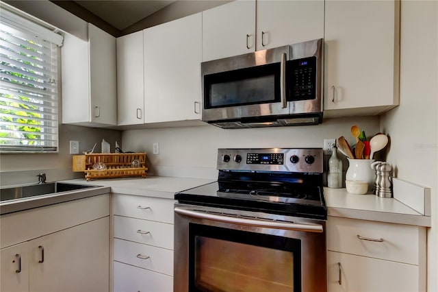 kitchen featuring a sink, light countertops, white cabinetry, and stainless steel appliances