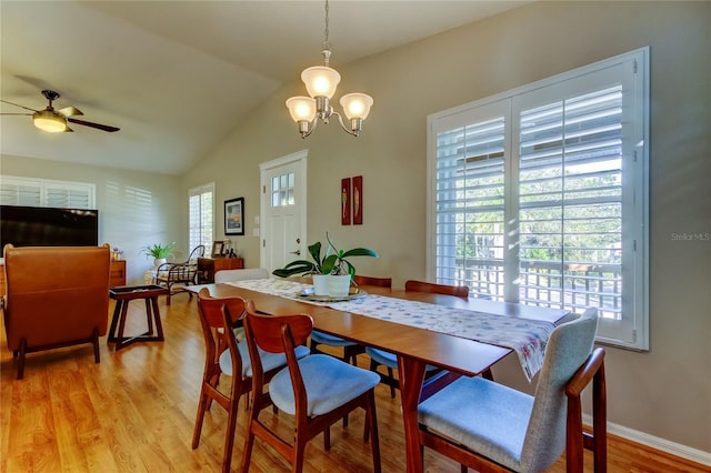 dining space featuring baseboards, vaulted ceiling, light wood-style floors, and ceiling fan with notable chandelier