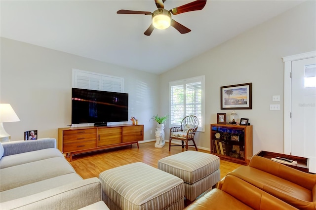 living area featuring light wood-style floors, baseboards, a ceiling fan, and lofted ceiling