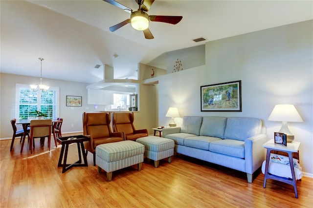 living room with light wood-style floors, visible vents, vaulted ceiling, and a healthy amount of sunlight