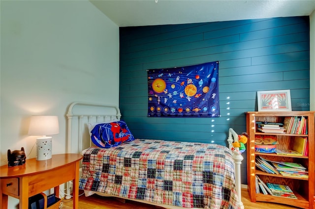 bedroom featuring wooden walls and wood finished floors