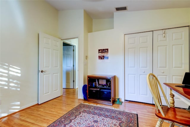 office area featuring visible vents, baseboards, vaulted ceiling, and wood finished floors