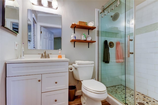 full bathroom featuring a shower stall, vanity, baseboards, and toilet