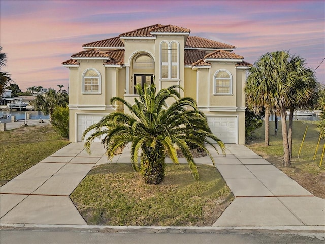 mediterranean / spanish-style home with an attached garage and stucco siding