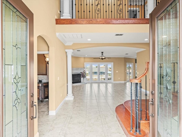 entryway with a ceiling fan, baseboards, visible vents, ornamental molding, and ornate columns