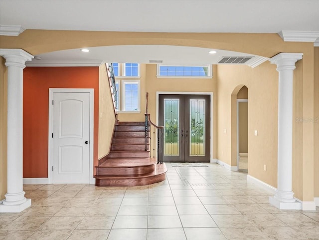 foyer featuring french doors, decorative columns, visible vents, ornamental molding, and stairs