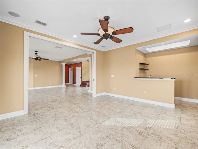 spare room with decorative columns, visible vents, arched walkways, and baseboards