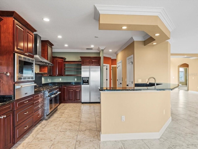 kitchen with arched walkways, a warming drawer, appliances with stainless steel finishes, wall chimney range hood, and dark brown cabinets