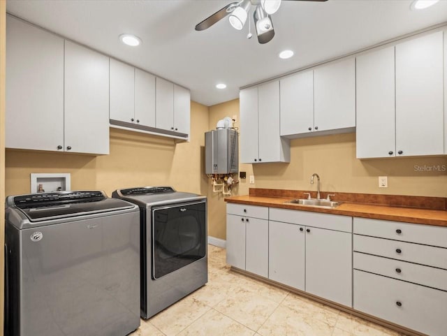 laundry area with cabinet space, a ceiling fan, tankless water heater, washing machine and dryer, and a sink