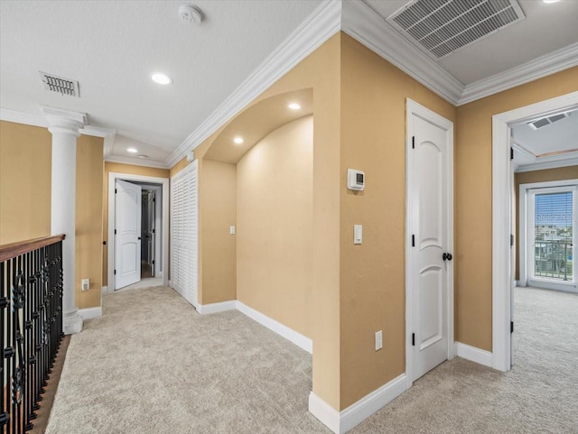 hallway featuring carpet floors, visible vents, and decorative columns