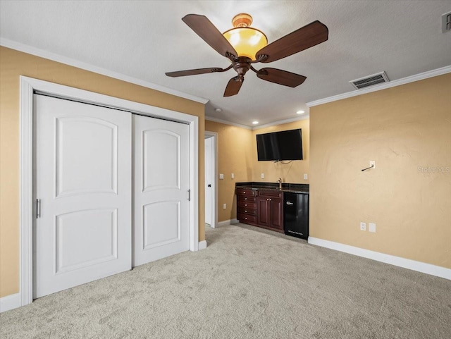 interior space with ornamental molding, refrigerator, light carpet, and visible vents