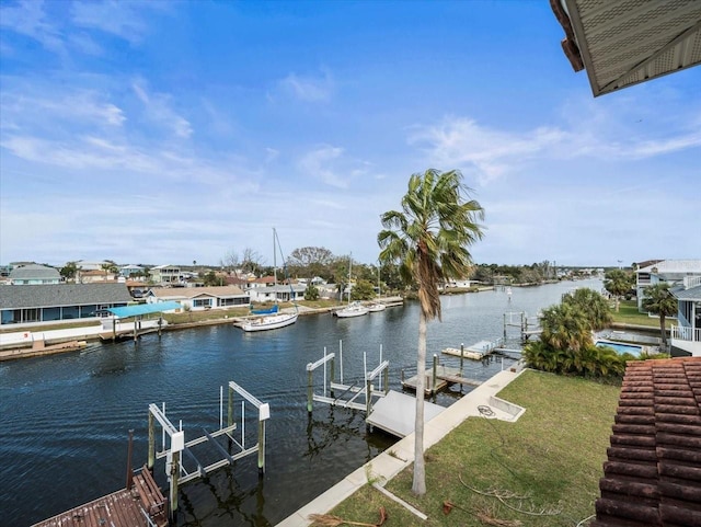 dock area with a water view, boat lift, and a lawn