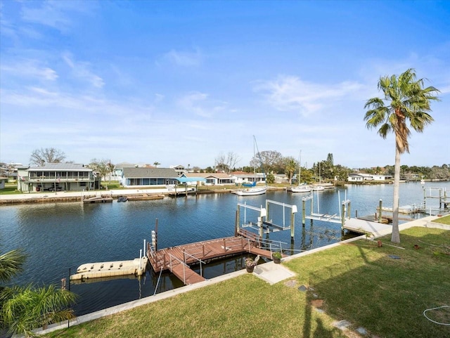 view of dock with a water view and a lawn