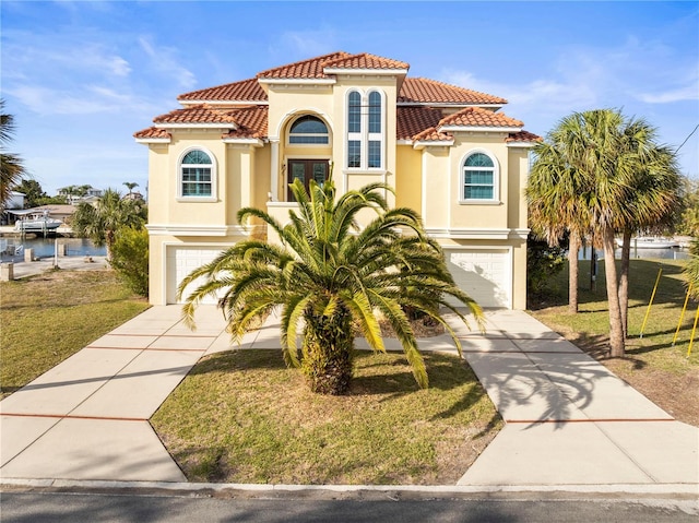 mediterranean / spanish home featuring driveway, an attached garage, a tile roof, and stucco siding