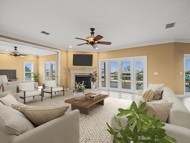 living area with light tile patterned flooring, visible vents, and a ceiling fan